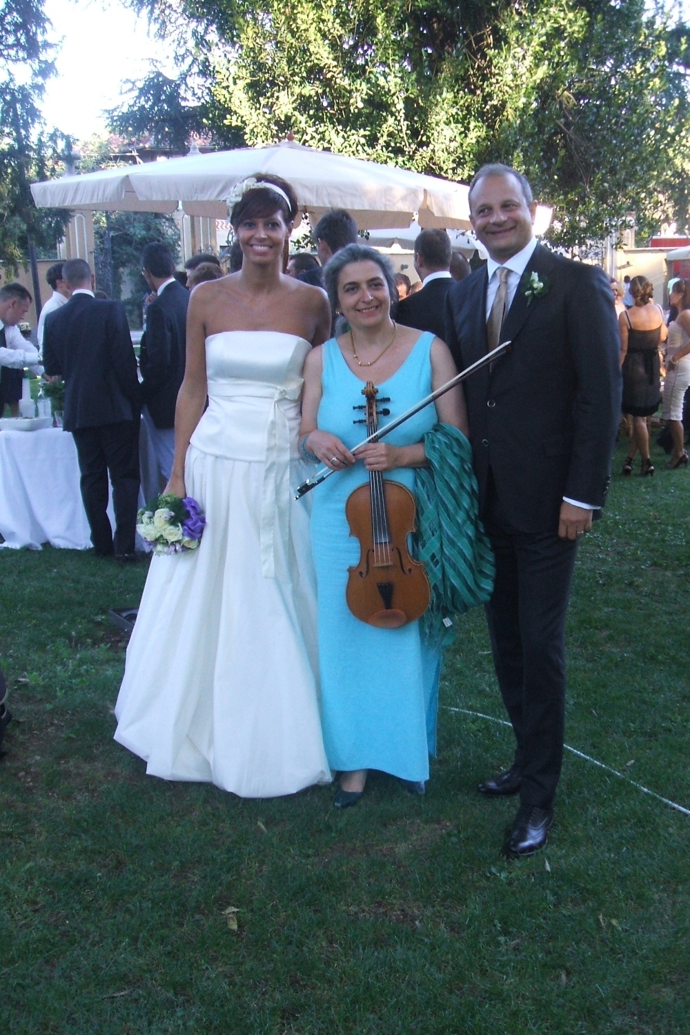 Gli sposi e la musicista che ha eseguito alla viola musica per ricevimento di nozze nel parco, Villa Caproni, Malpensa.