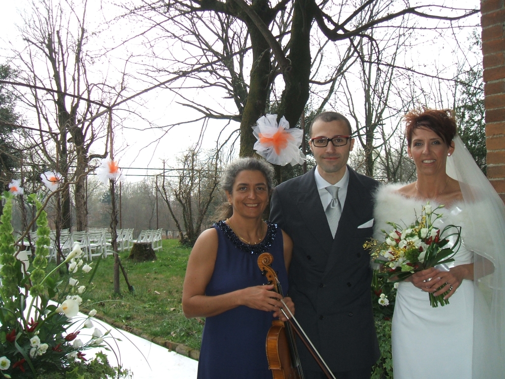Bride and groom with wedding musician after their civil wedding ceremony in the garden of a castle, near Milan, Italy